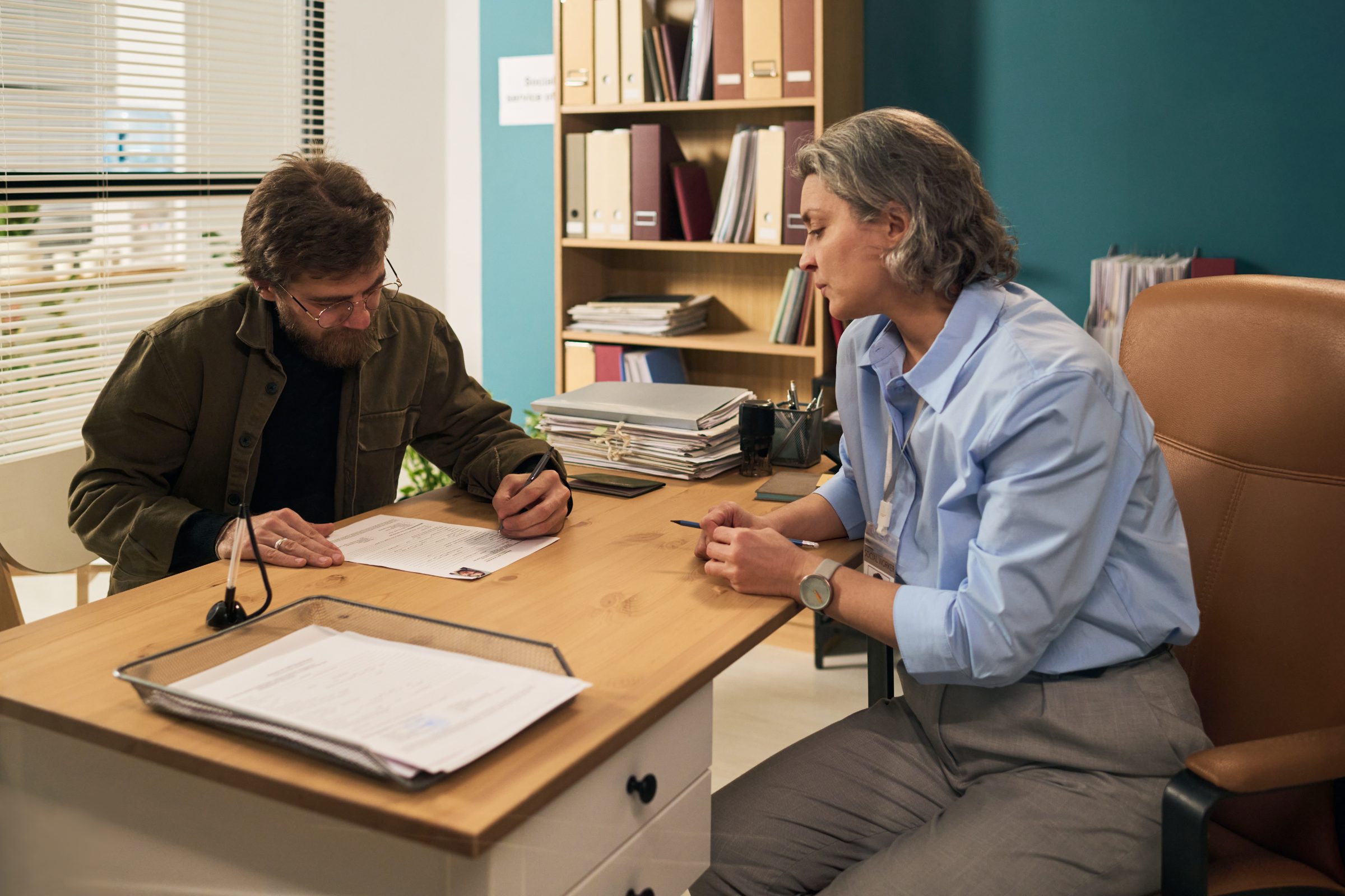 A veteran reviewing benefits paperwork with a counselor at a desk